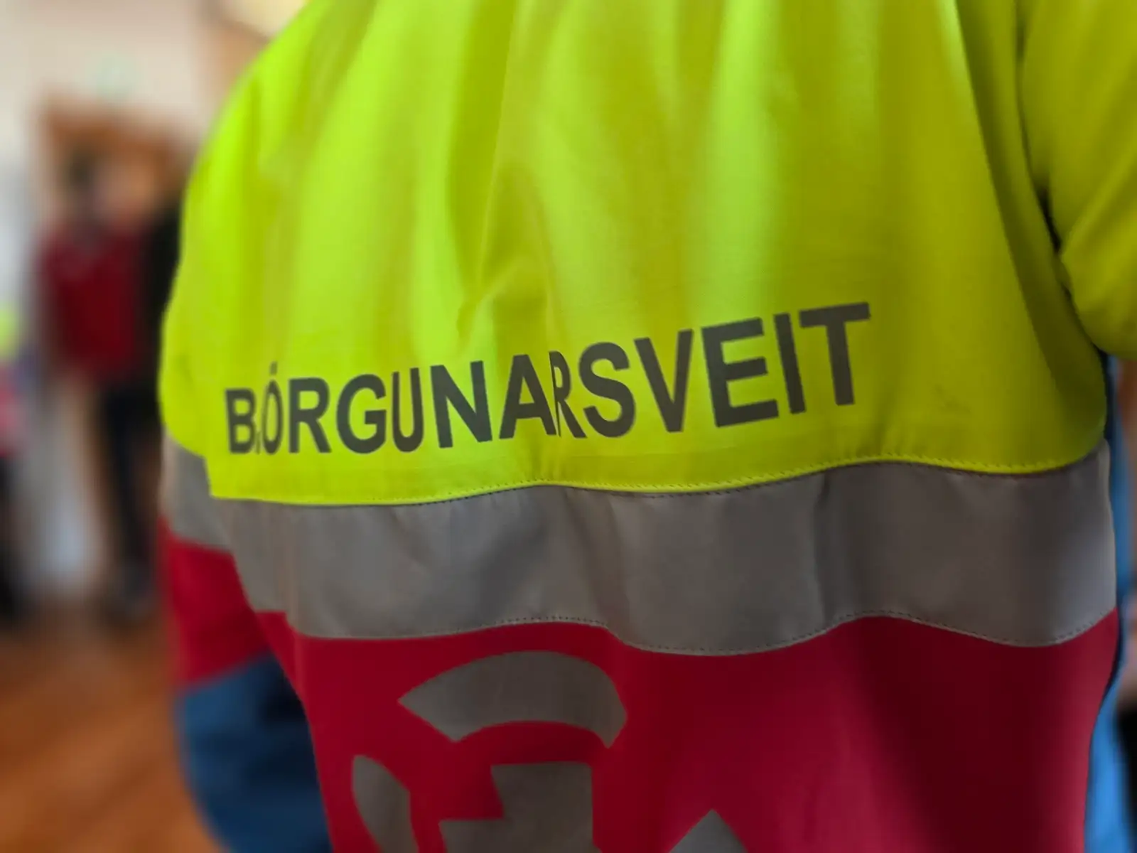 Nærmynd af baki einkennisklædds björgunarsveitarmanns. Á úlpu hans stendur orðið björgunarsveit þvert yfir bakið.