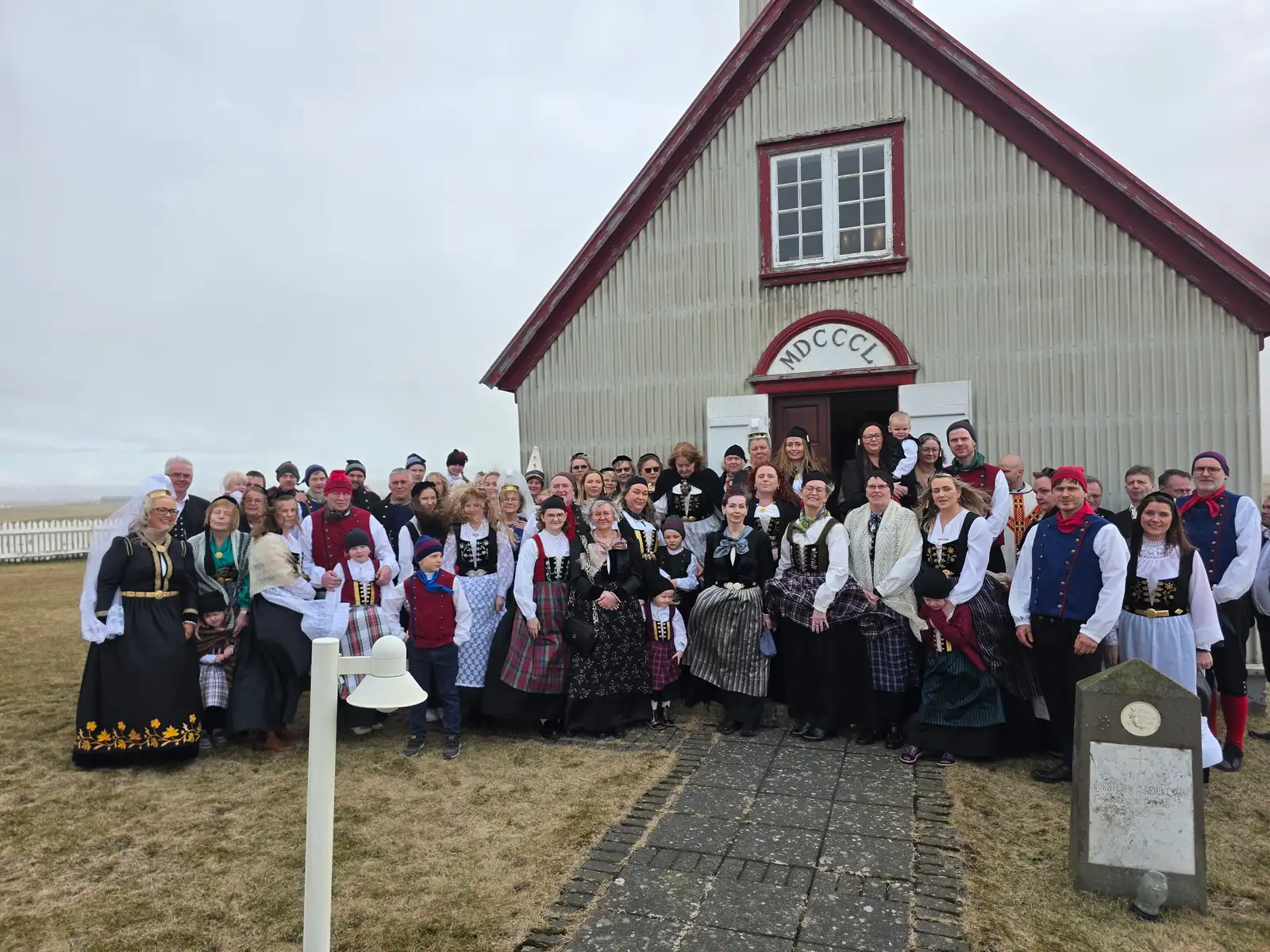 Á myndinni standa þátttakendur þjóðbúningamessu árið 2026 fyrir utan Krosskirkju í Austur-Landeyjum.