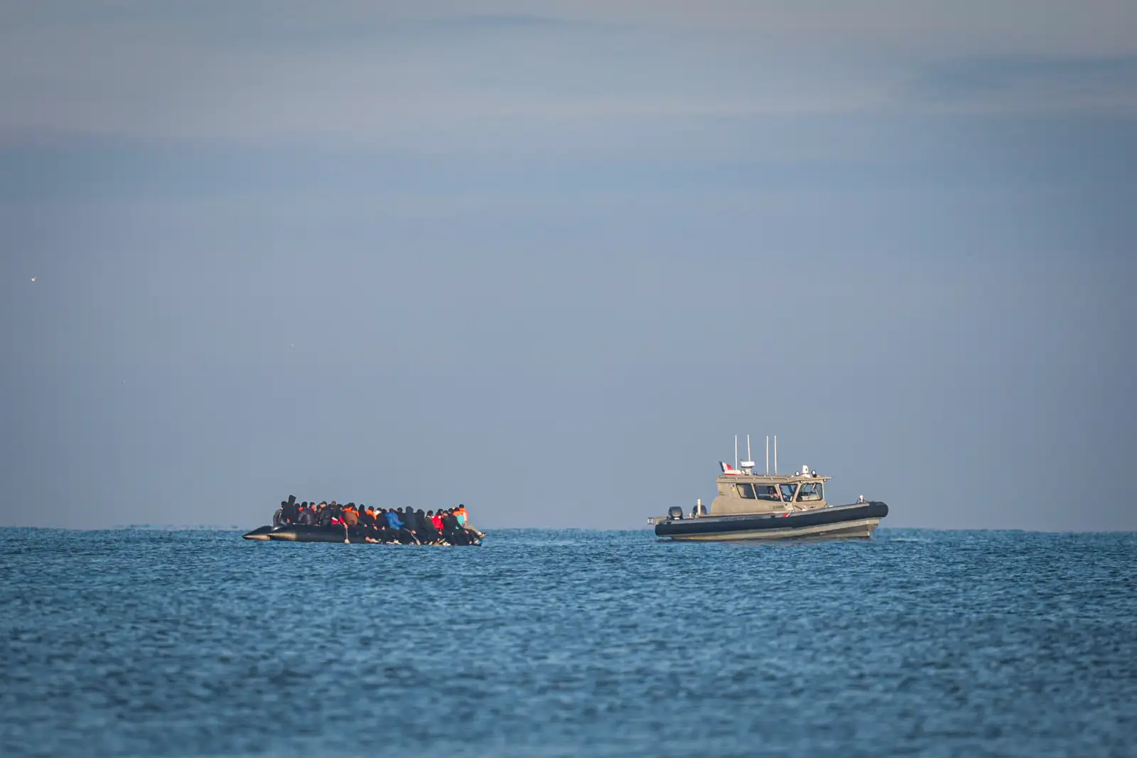 epa12409625 A French Coats Guard boat (R) patrols as migrants onboard an inflatable boat attempt to cross the English Channel, off the beach of Gravelines, northern France, 27 September 2025.  EPA/FADEL DAWOD