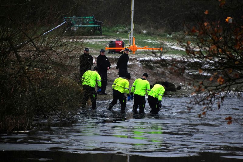Police search teams at the scene after children fell through ice,in Babbs Mill Park in Kingshurst, Solihull, England, Monday, Dec. 12, 2022. Three young boys who fell through ice covering a lake in central England have died and a fourth remains hospitalized as weather forecasters issued severe weather warnings for large parts of the United Kingdom. Rescuers pulled the boys, aged 8, 10 and 11, from the icy waters Sunday afternoon and rushed them to the hospital in the West Midlands, about 100 miles (160 kilometers) north of London. But they could not be revived after suffering cardiac arrest. (Matthew Cooper/PA via AP)