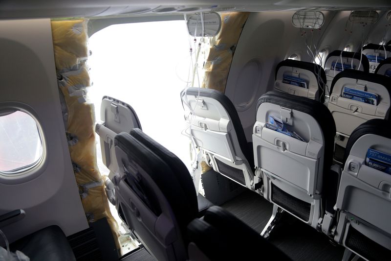 Myndin er tekin inni í Boeing 737 MAX 9 þotu Alaska Airlines. Á myndinni sést hvernig hluta skrokksins vantar og stórt gat er við hlið einnar sætaraðar.
