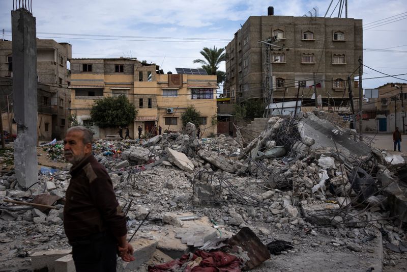 Maður stendur fyrir frama húsarústir eftir árás ísraelska hersins á byggingu í borginni Rafah á Gaza-svæðinu. Hrúgur af steypu og járnum liggja þar sem húsið stóð.