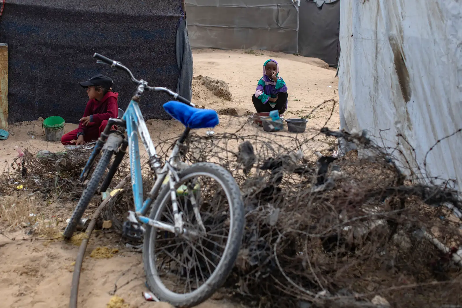 epa12069088 Internally displaced Palestinian children rest as they gather to receive food from a charity kitchen in Khan Yunis, southern Gaza Strip, 02 May 2025. According to the UN Palestinian refugee agency UNRWA, over a million people across the Gaza Strip are experiencing 'high levels' of acute food insecurity, with acute malnutrition several times higher than before the war. The UN estimates at least 1.9 million people (nine in ten) are internally displaced.  EPA-EFE/HAITHAM IMAD