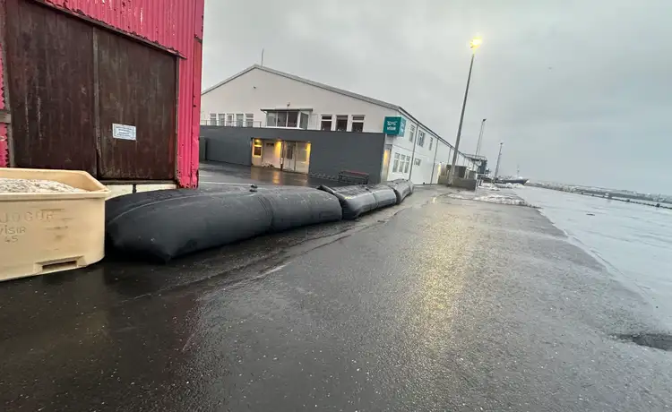 Pictures show a barrier made of rubber balloons that was placed on the pier in Grindavík to protect against sea currents.