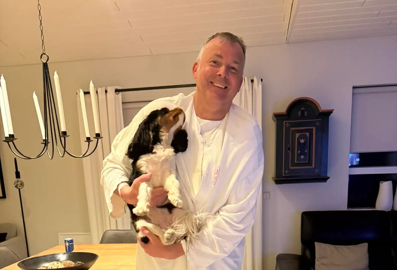 Jón Pétur Zimsen með hundinn Kviku í fanginu, klæddur fötum sem hann fékk á Landspítalanum eftir að hafa lent í sjónum og ofkælst.