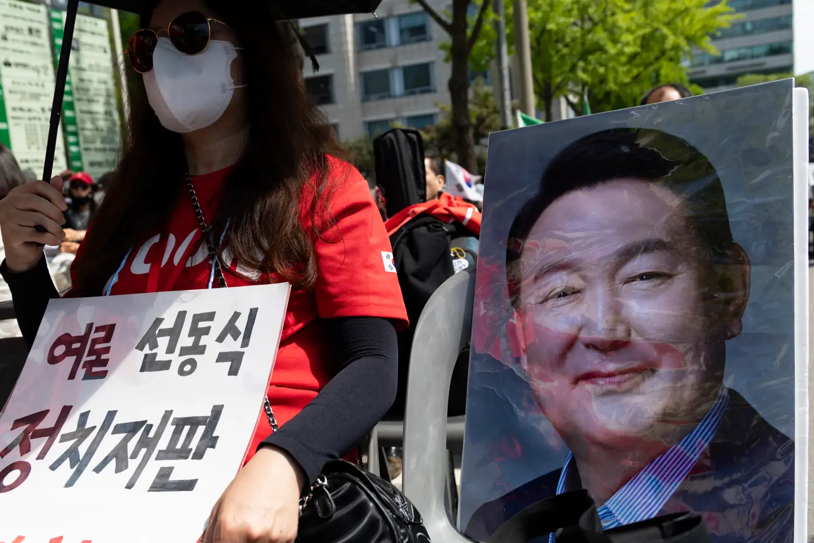 epa12920939 A supporter of impeached former South Korean President Yoon Suk Yeol holds up a picture of Yoon as they rally outside the Seoul High Court in Seoul, South Korea, 29 April 2026. An appeals court increased the sentence of former South Korean President Yoon Suk Yeol from five to seven years in prison on 29 April, on obstruction of justice and other charges stemming from his failed martial law bid. A lower court sentenced him to five years in prison on 16 January 2026.  EPA/JEON HEON-KYUN