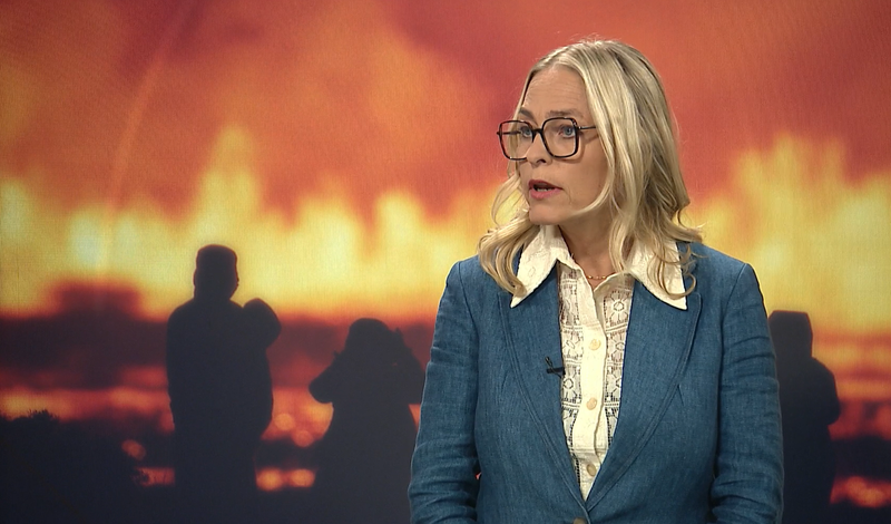 Kristín Jónsdóttir vom Isländischen Meteorologischen Amt in einem Interview in den Fernsehnachrichten. Hinter ihr sind Bilder vom Ausbruch.