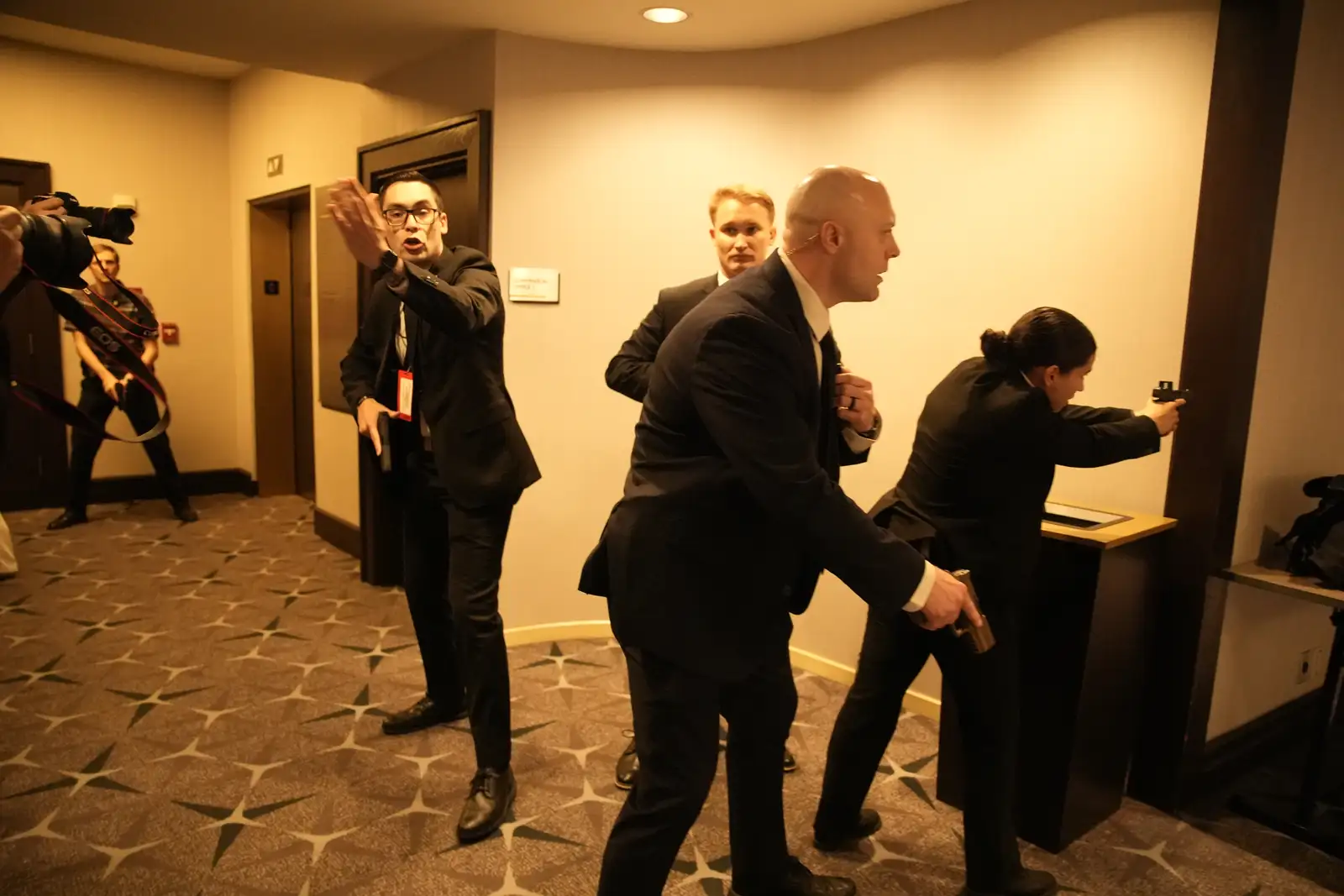 epa12914366 Security personnel stand on alert after hearing shots fired at the White House Correspondents' Association Dinner, where US President Donald Trump and First Lady Melania Trump are attending in Washington, DC, USA, 25 April 2026. Attendees, including US President Donald Trump, were evacuated at the White House Correspondents’ Dinner after shots were fired at the venue.  EPA/Yuri Gripas / POOL