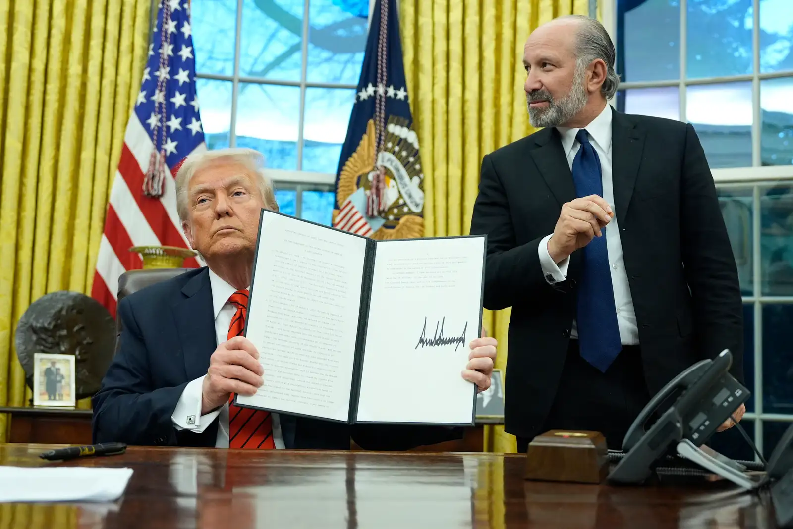 President Donald Trump displays a signed proclamation regarding steel imports as he speaks in the Oval Office at the White House, Monday, Feb. 10, 2025, in Washington, as Commerce Secretary nominee Howard Lutnick watches. (Photo/Alex Brandon)