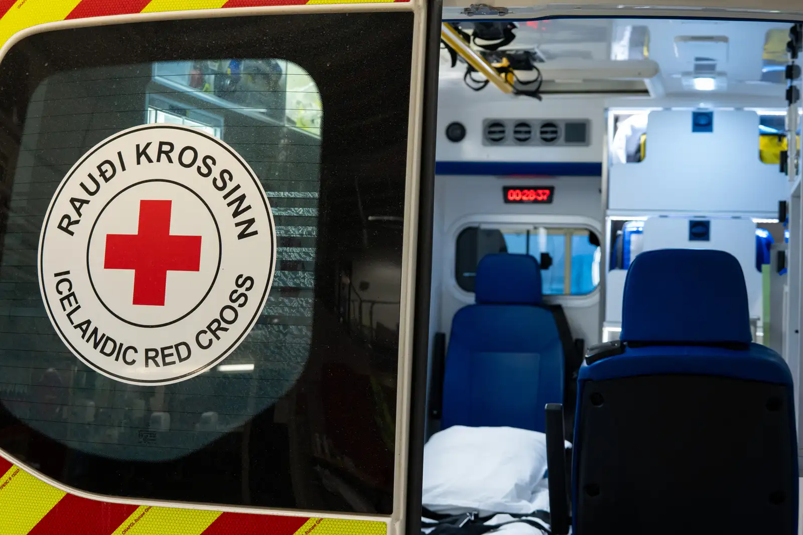 Hálfopin hurð sjúkrabíls með merkingu Rauða Krossinns á hurðinni