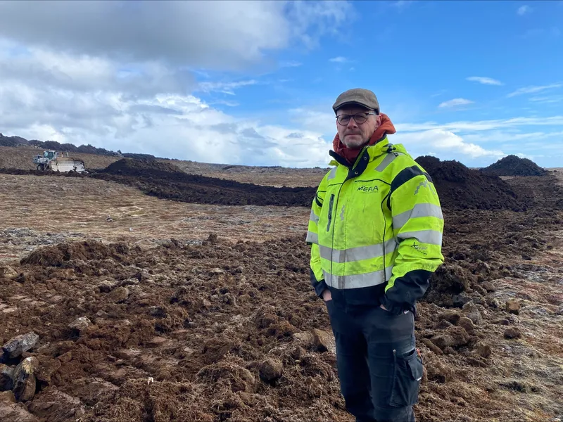 Jón Haukur Steingrímsson, jarðverkfræðingur hjá Eflu, stendur fyrir framan varnargarða við Grindavík. Fyrir aftan hann má sjá framkvæmdir við nýja garða sem verið er að reisa.