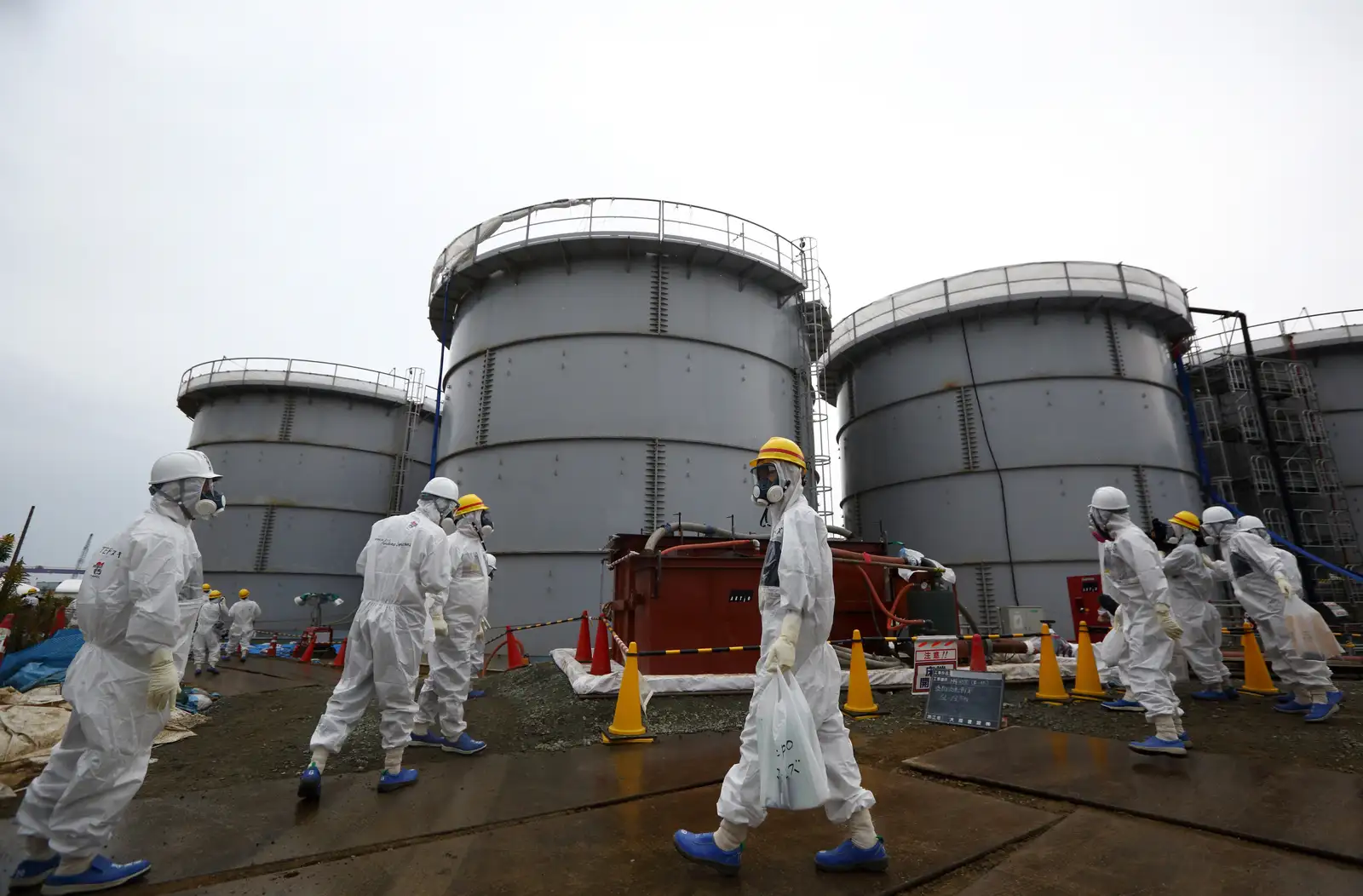 epa12811808 (FILE) - Members of the media and Tokyo Electric Power Co. (Tepco) employees wearing protective suits and masks walk past storage tanks for radioactive water in the H4 area at the Fukushima Dai-ichi nuclear power plant in Okuma, Fukushima Prefecture, Japan, on 07 November 2013 (reissued 10 March 2026). On 11 March 2011, a magnitude 9.0 earthquake off the coast of Japan's Tōhoku region triggered a 40-meter tsunami that destroyed coastal towns, killed nearly 18,500 people, destroyed infrastructure, and triggered the TEPCO Fukushima Daiichi nuclear crisis.  EPA/TOMOHIRO OHSUMI / POOL JAPAN OUT *** Local Caption *** 51092299