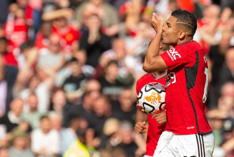 Brasilíumaðurinn Casemiro fagnar marki sínu gegn Nottingham Forest í ensku úrvalsdeild karla í fótbolta. Hann kyssir úlnlið sinn og heldur á boltanum. Í bakgrunn er stútfull stúkan en hann er íklæddur skærrauðum búning United.