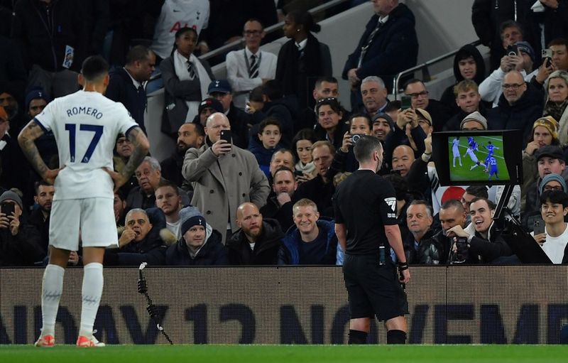 Varnarmaður Tottenham og Argentínu í fótbolta, Christian Romero, fylgist með dómaranum Michael Oliver er Oliver lítur á VAR myndbandskjáinn. Romero fékk rautt spjald.