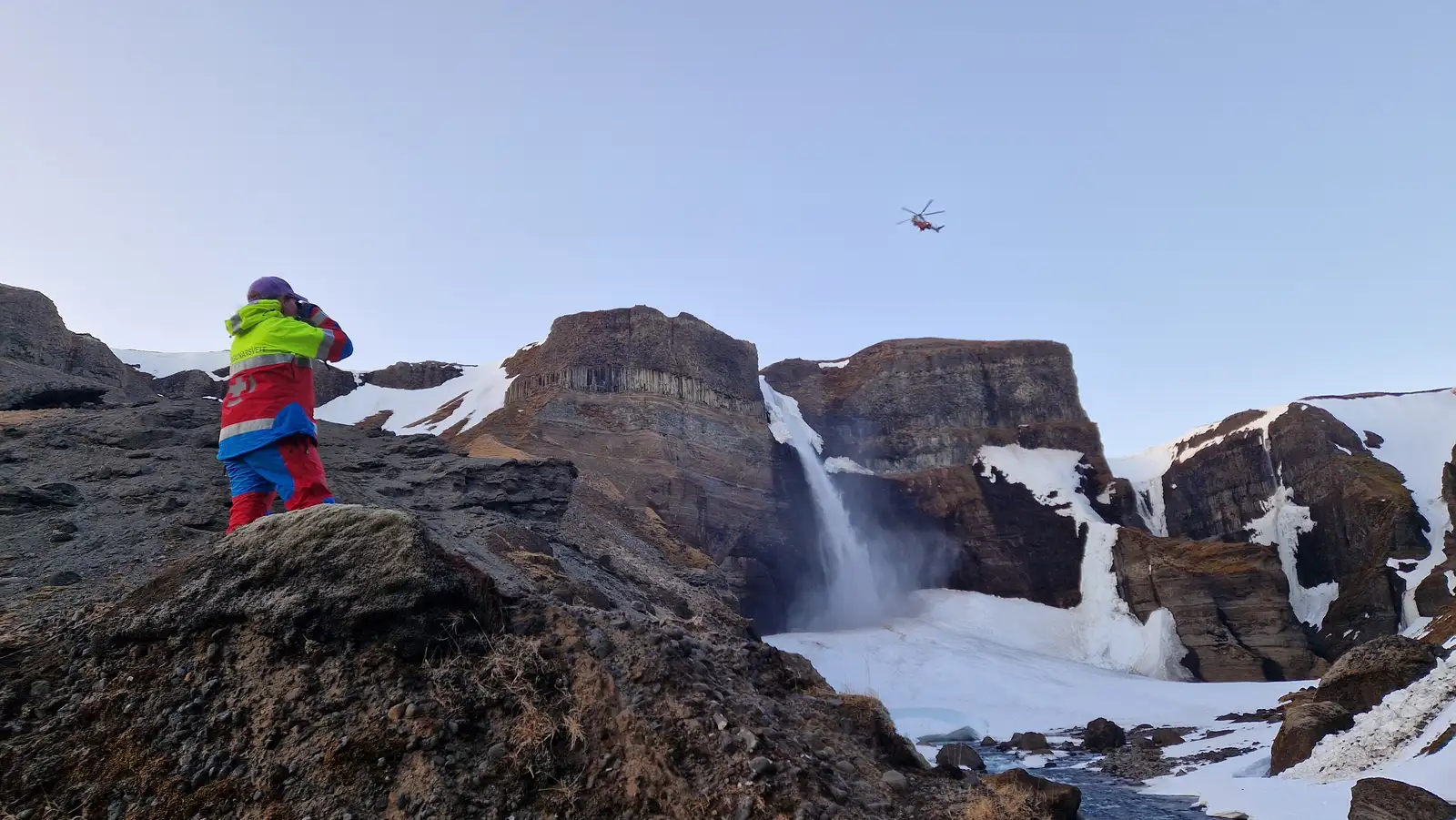Björgunarsveitarmaður leitar erlends ferðamanns í grennd við Háafoss í Þjórsárdal. Þyrla Landhelgisgæslunnar flýgur yfir leitarsvæðinu.