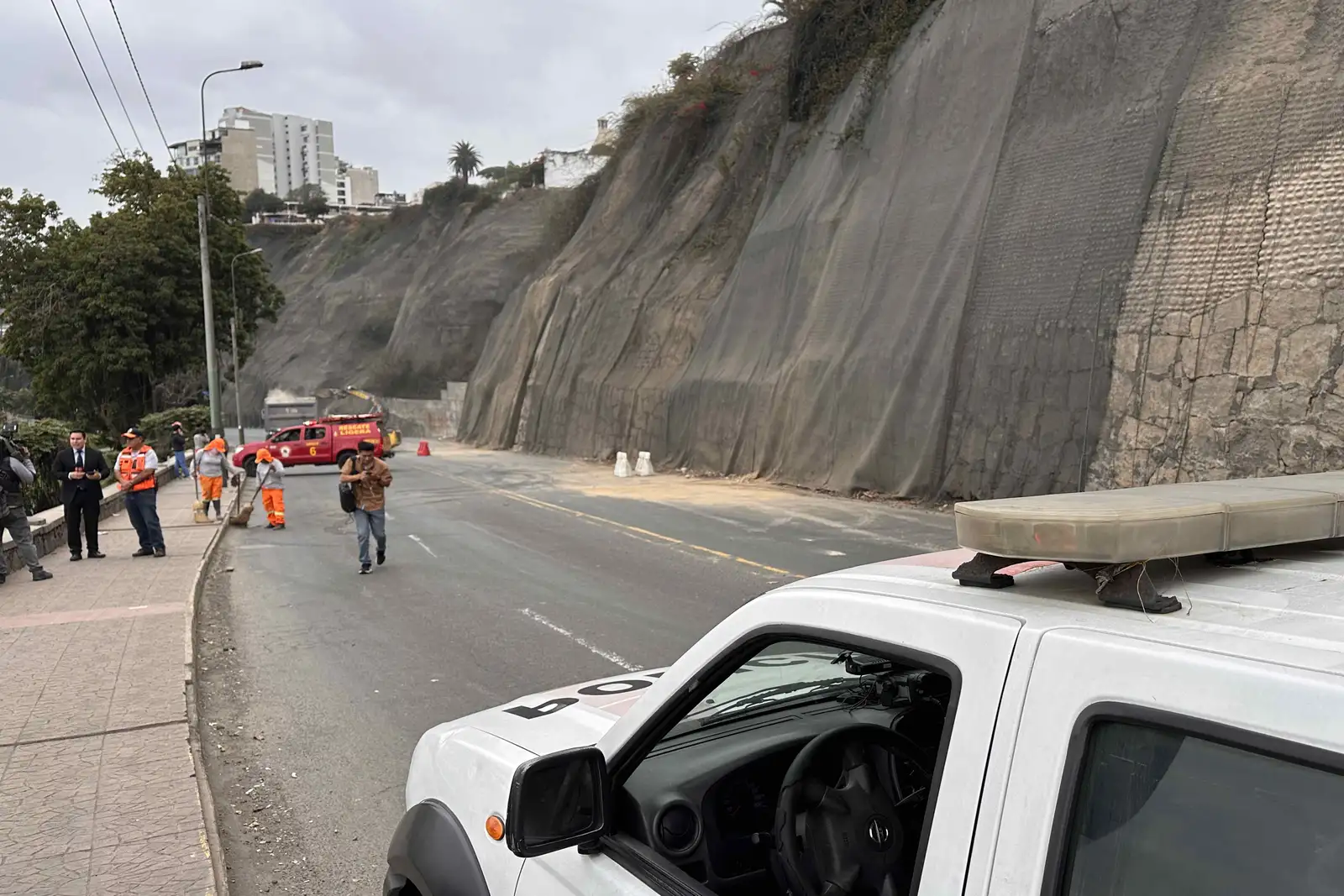 epa12177887 Firefighters and police vehicles close Costa Verde Avenue due to cliff collapses caused by an earthquake in Lima, Peru, 15 June 2025. A magnitude 6.1 earthquake shook Lima and neighboring Callao, on 15 June, there have been no official reports of personal or property damage.  EPA-EFE/Mikhail Huacan